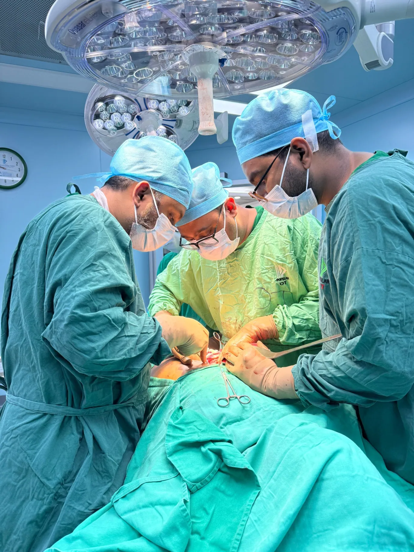 Three surgeons performing gallbladder operation at Popular Medical