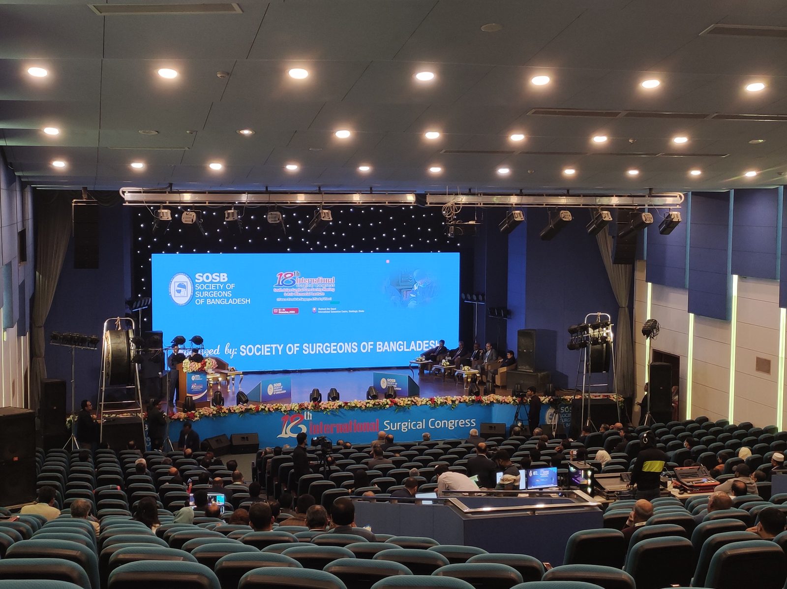 A surgical congress auditorium in Dhaka discussing the importance of end to end surgical case ownership in training.