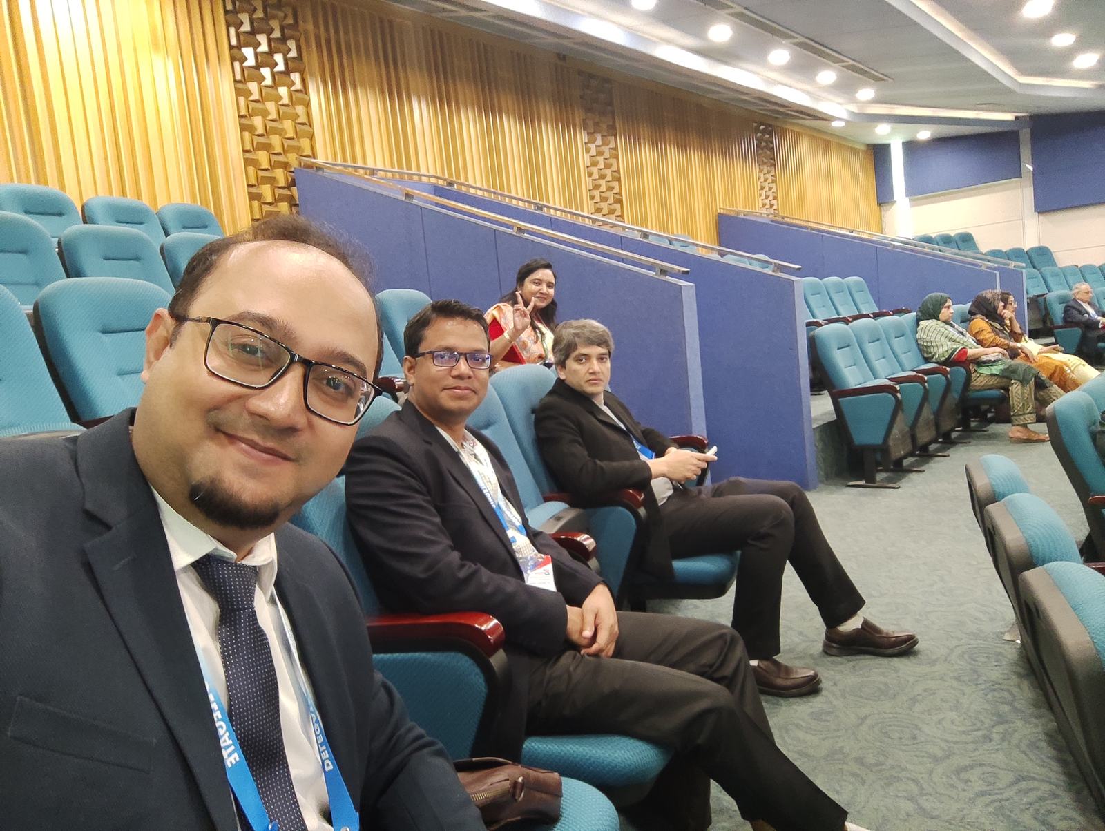 Formally dressed medical professionals at a conference discussing advancements in gallbladder surgery.