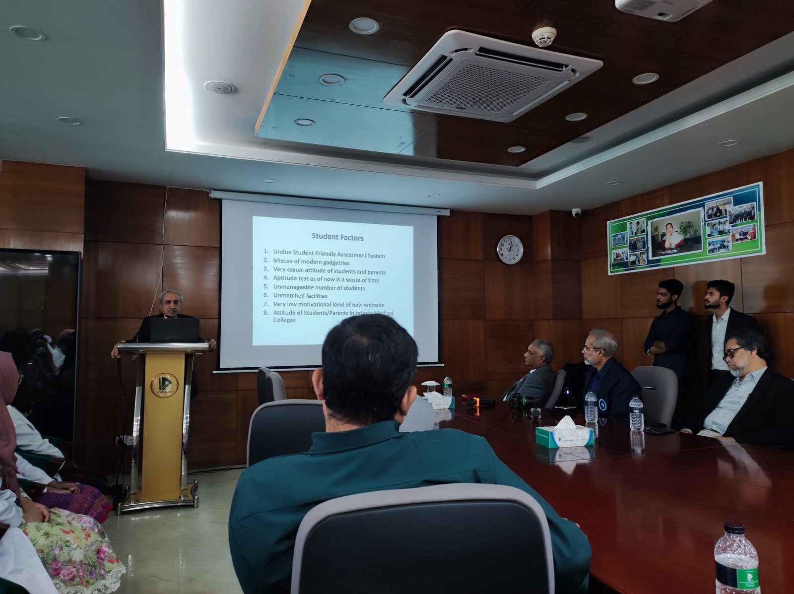 Academic Presentation by Laparoscopic Surgeon Dhaka Medical lecture led by a laparoscopic surgeon Dhaka in a wood-paneled conference room during a professional seminar.